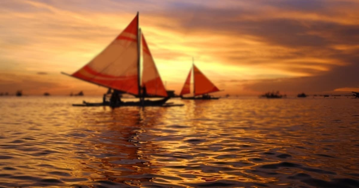 夕日の海の上に2隻のヨット