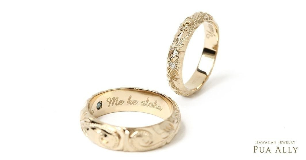 内側にブルーダイヤと文字の入った金の指輪と、ダイヤモンドの入ったゴールドの指輪