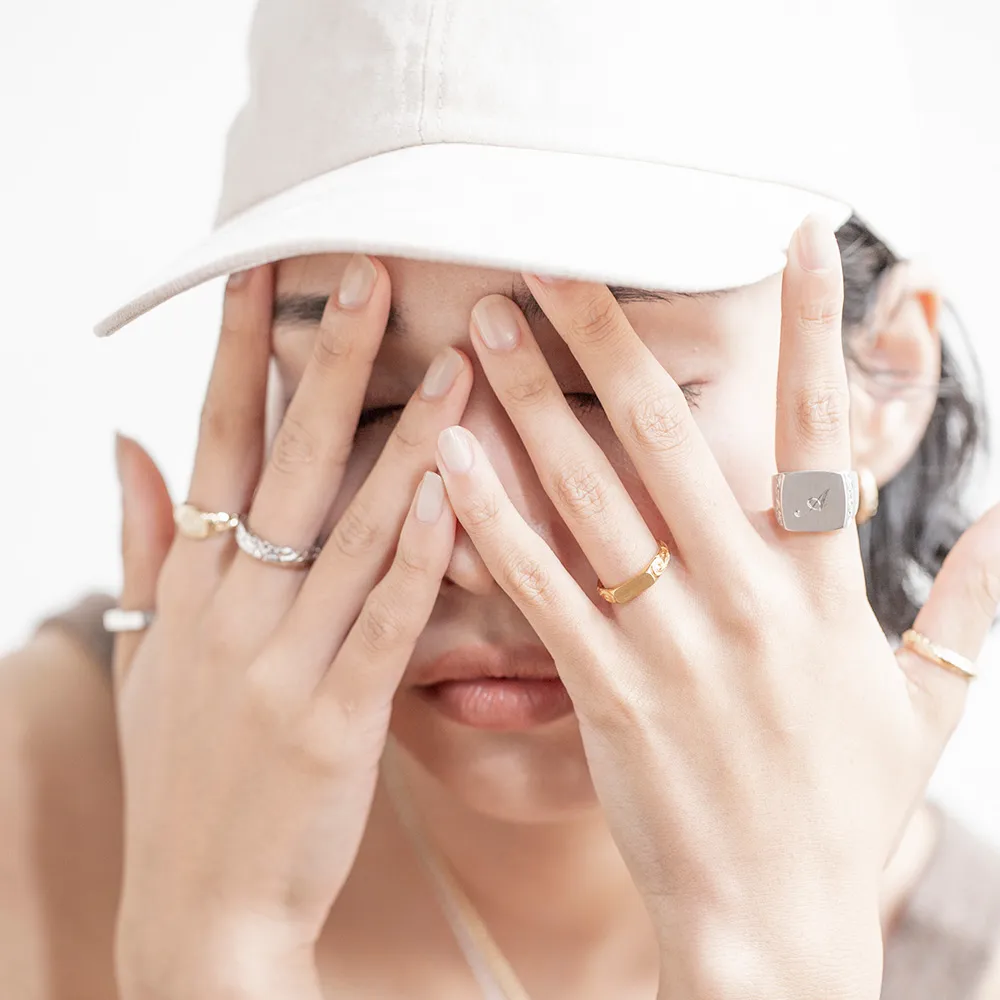 指にプアアリのハワイアンジュエリーを6個身につけて顔の前でポーズしている女性の画像