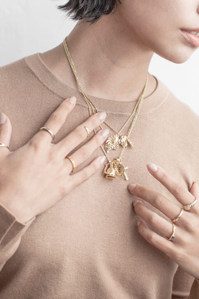 ハワイアンジュエリーネックレスとリングを沢山着けている女性