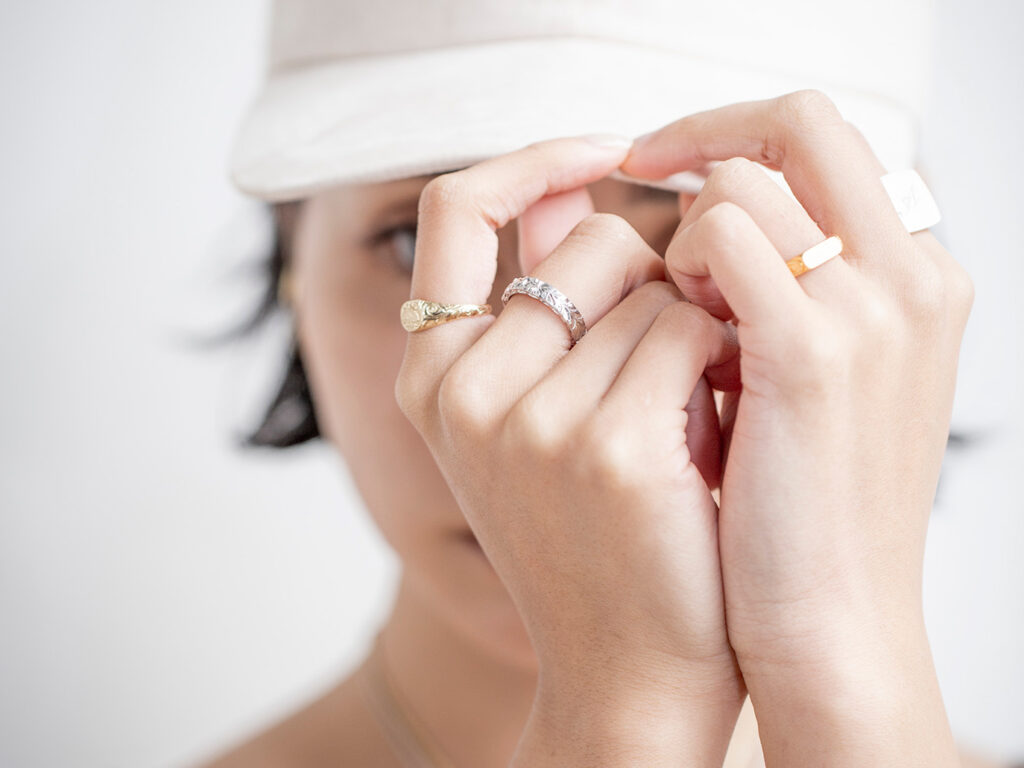 ハワイアンジュエリーリングを女性が組み合わせて複数着用