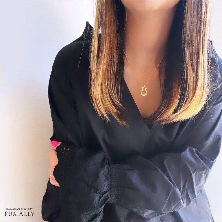 （10000733）黒いトップスを着た女性がハワイアンジュエリーホースシューネックレスＭサイズを着用
