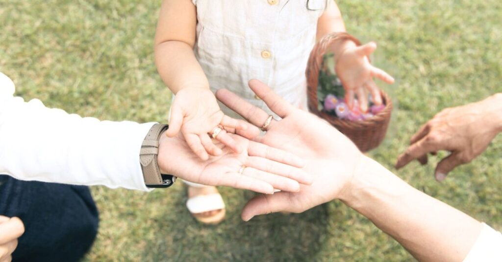 パパとママと子供の手が重なり、結婚指輪とお揃いのベビーリング