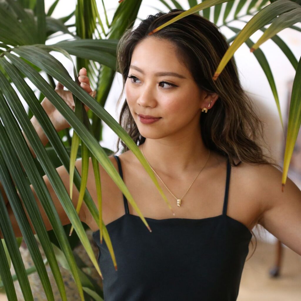 (10001604)アヌエヌエピアスを身に着けてヤシの木をかき分ける女性