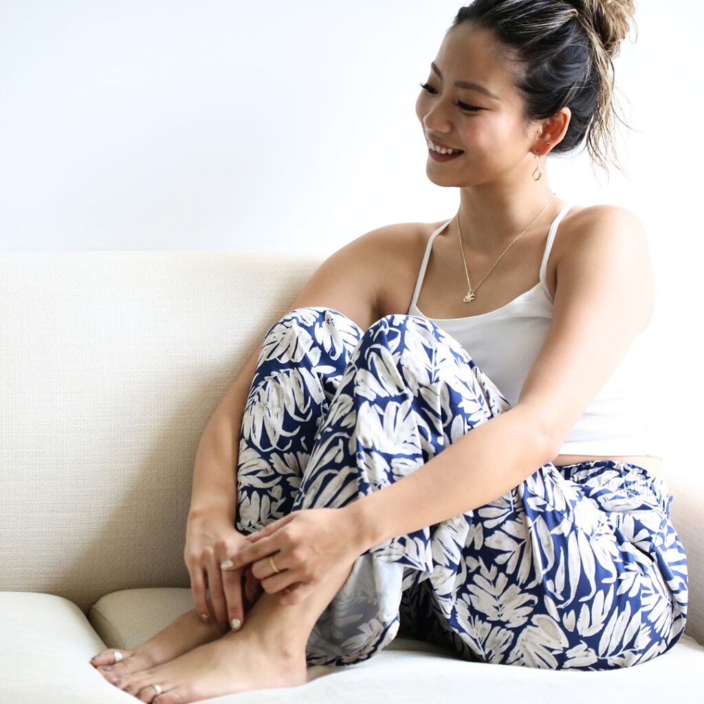 (10001591)スワロウネックレスを着けてソファに座る女性