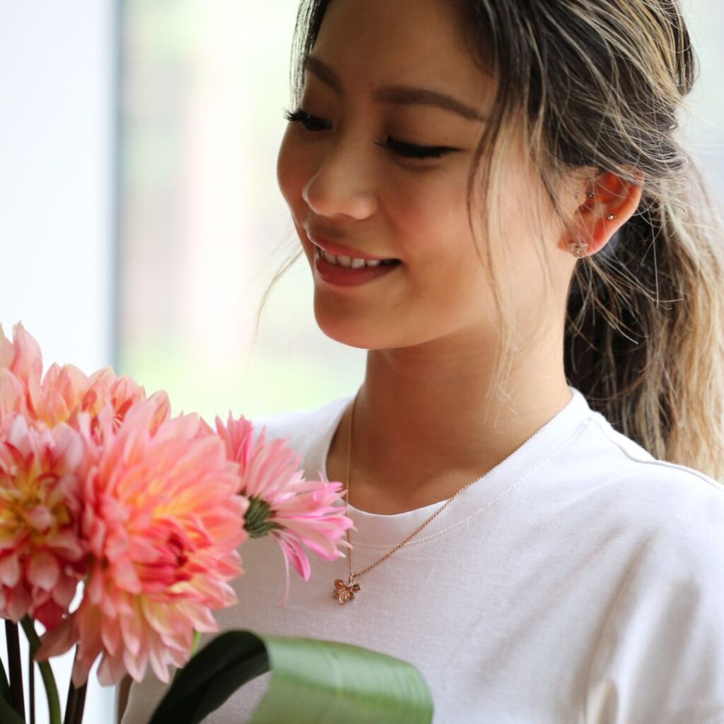 (10001620)ナウパカネックレスを身に着け花束を見る女性