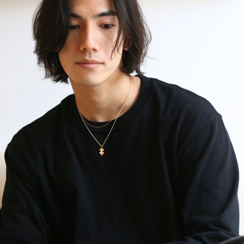 パズルネックレスプレーンを着けた男性