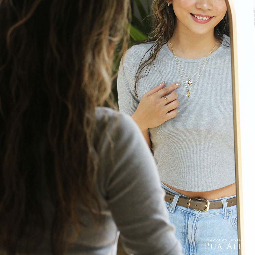 女性が鏡を見ながらネックレスを重ね着け