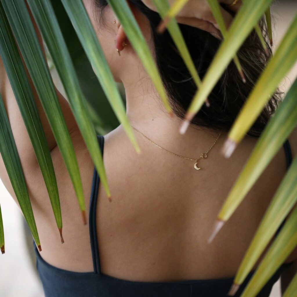 (1001607)ラハイナネックレスの月チャームを付けた女性の背中