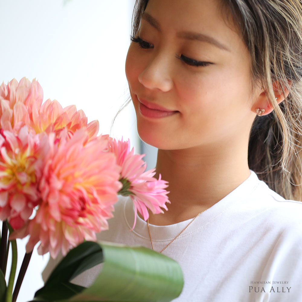(10001617)ブーゲンビリアのピアスを着けてピンクの花束を見つめる女性